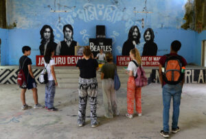 This picture taken on June 18, 2018 shows tourists taking pictures of a mural at the now-derelict ashram visited by the Beatles 50 years ago, in Rishikesh in northern India. - Fifty years after the Beatles came to India, the bungalows where the Fab Four lived, the post office where John Lennon sent Yoko Ono postcards and the giggling guru's house are all ruins. (Photo by Sajjad HUSSAIN / AFP)        (Photo credit should read SAJJAD HUSSAIN/AFP via Getty Images)